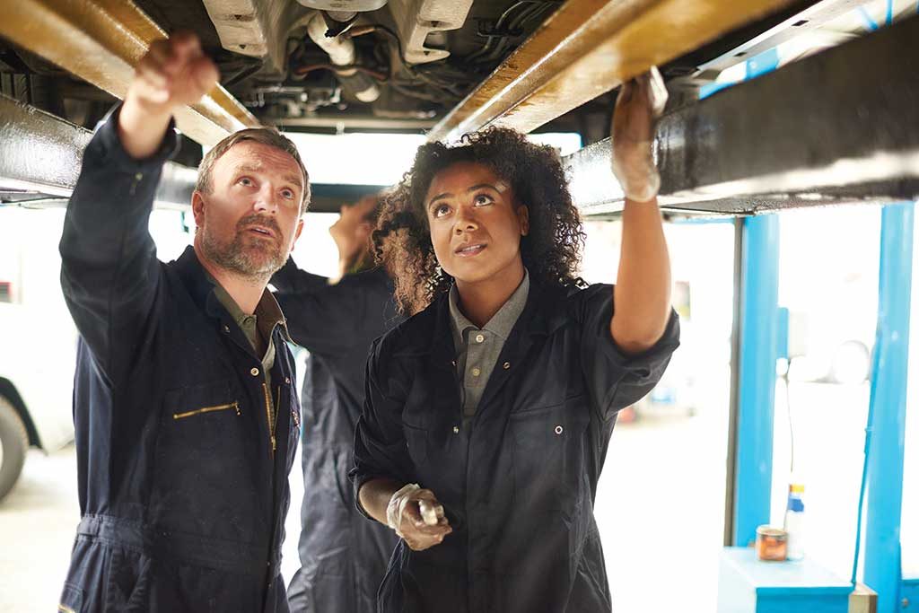 Stock photo of two mechanics working in their factory to fix something